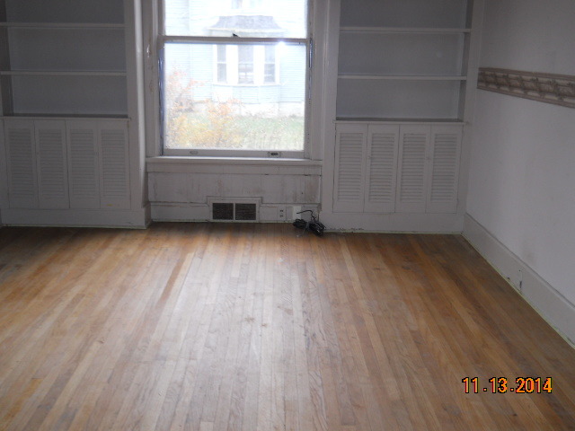 802 West 3rd Street Sterling, IL 61081 - Photo 5 of 21 an empty room with wooden floor and windows