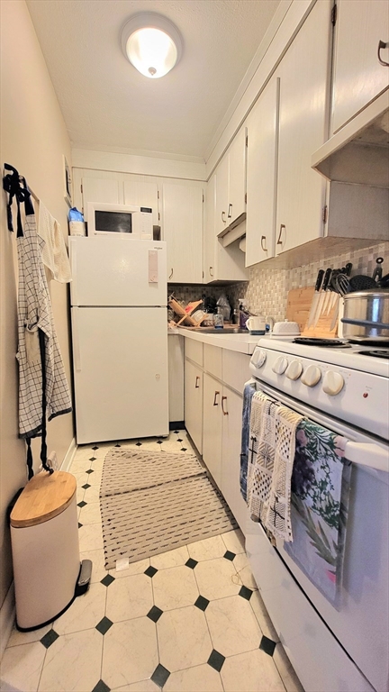 200 Kelton Street, Unit 14 Boston, MA 02134 - Photo 6 of 7 a kitchen with a white stove top oven and white cabinets