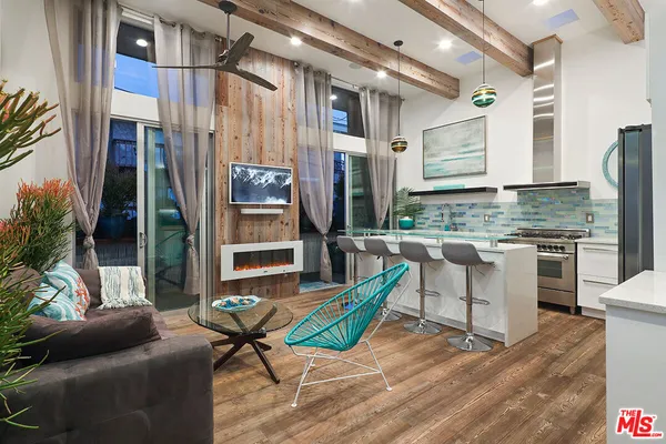 a living room with furniture a flat screen tv and floor to ceiling window