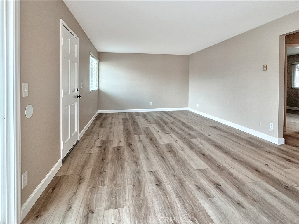 16941 Sims Lane, Unit B Huntington Beach, CA 92649 - Photo 2 of 12 Living room is spacious, with vinyl plank floors - and unit B has a patio off sliding door. This photo is of Apt C upstairs, but the units are identical except for the patio.