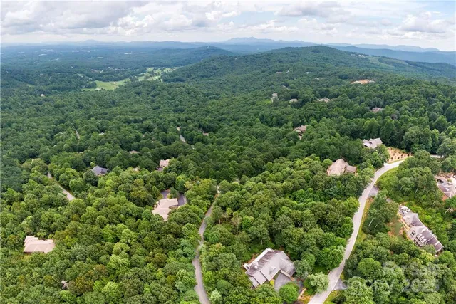 an aerial view of a house with a yard and outdoor seating