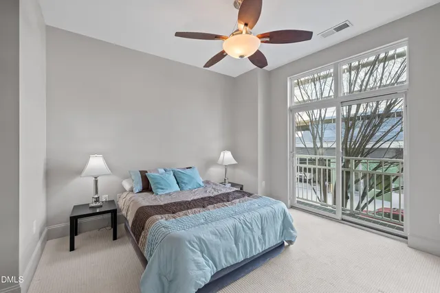 a bedroom with a large bed and a chandelier fan
