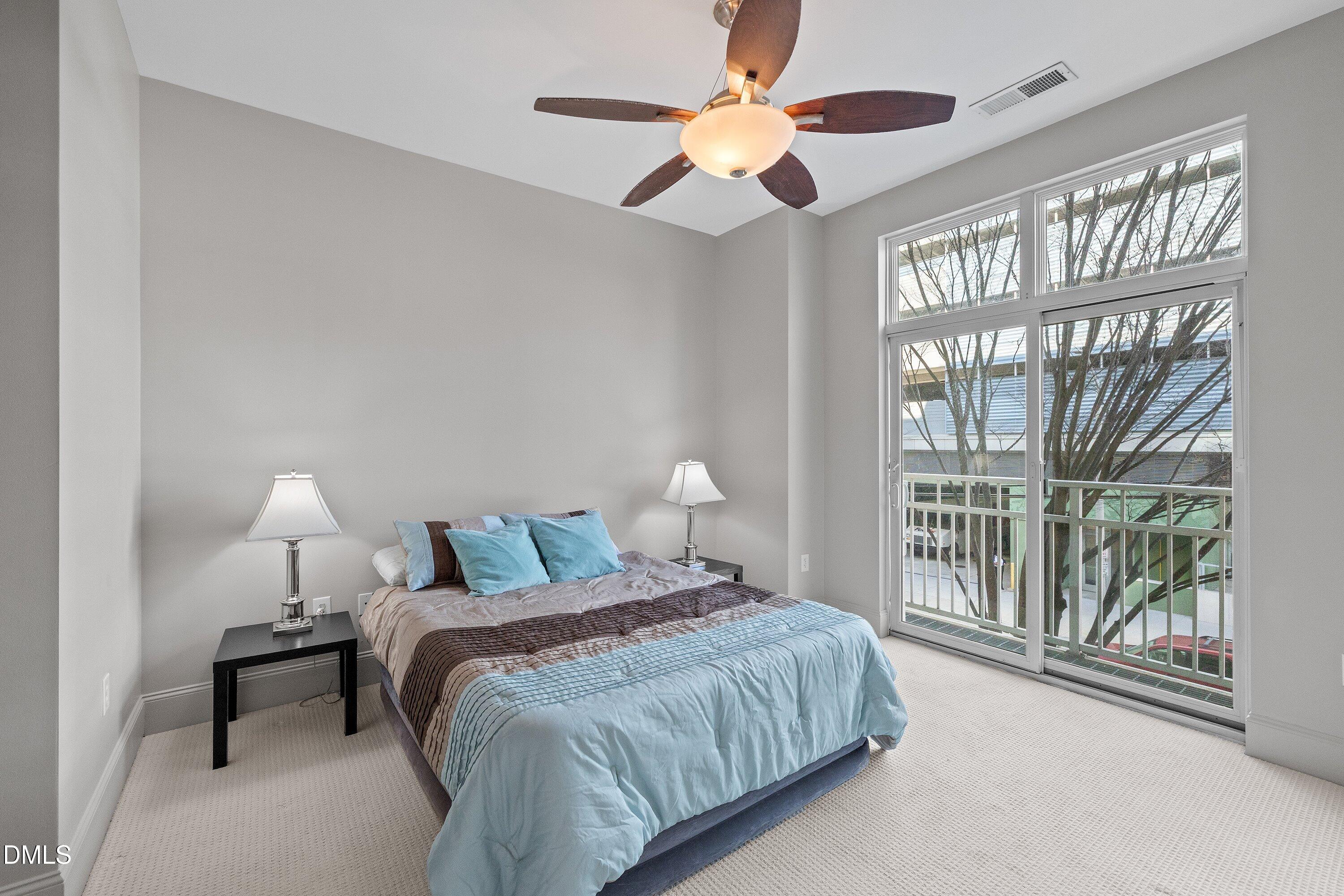 a bedroom with a large bed and a chandelier fan