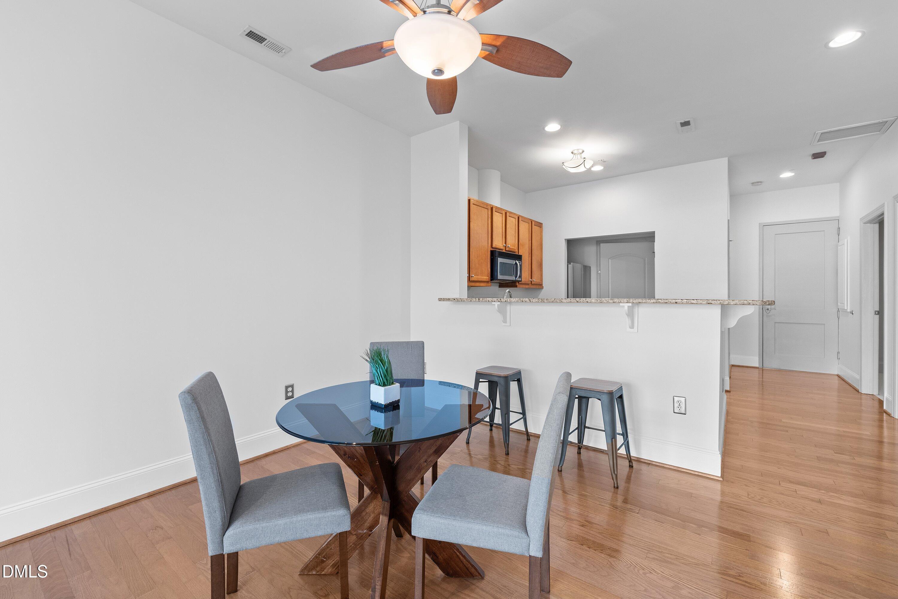 317 West Morgan Street, Unit 215 Raleigh, NC 27601 - Photo 12 of 38 a view of a dining room with furniture and wooden floor