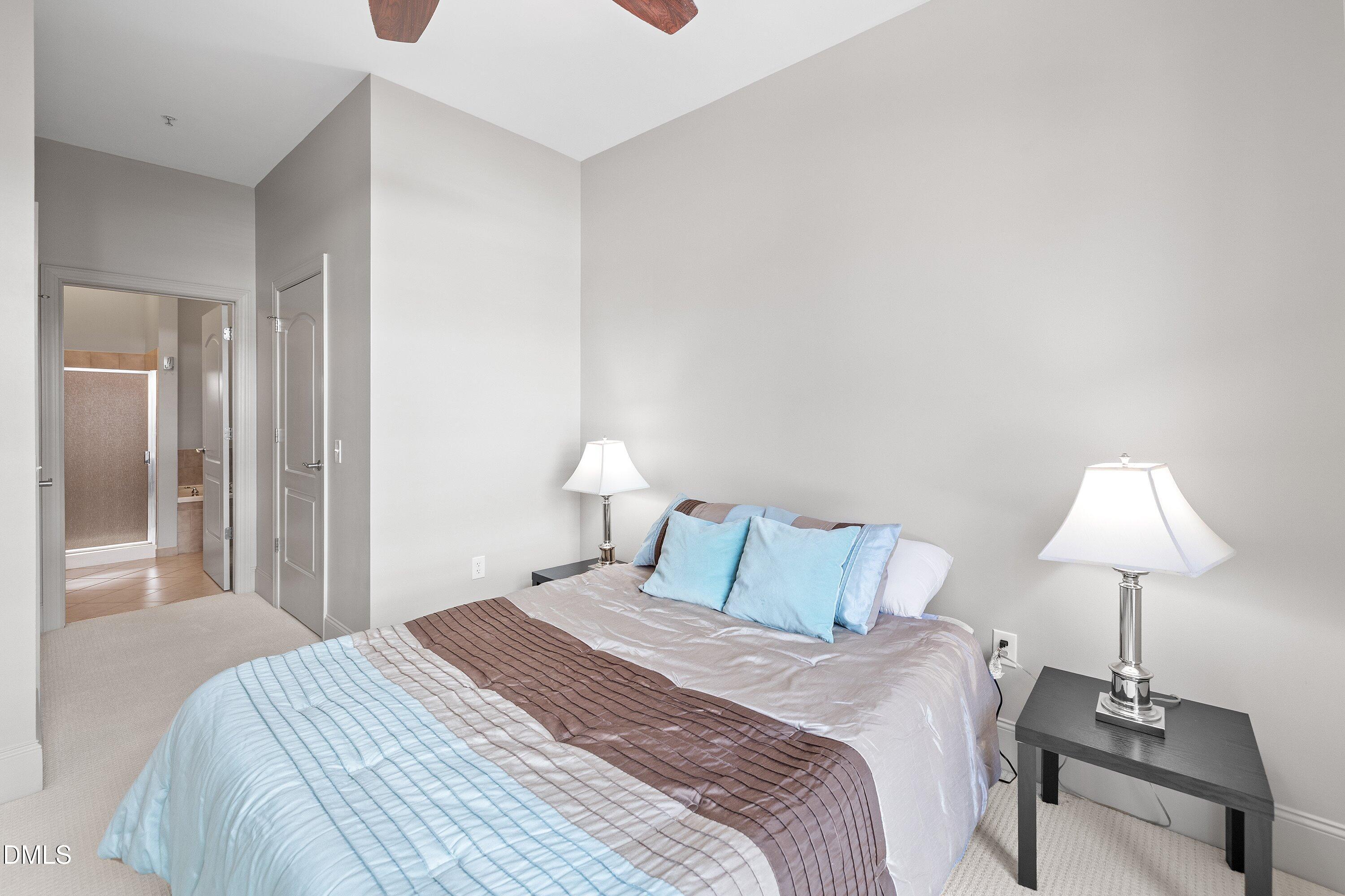 317 West Morgan Street, Unit 215 Raleigh, NC 27601 - Photo 18 of 38 a bedroom with a bed and a lamp