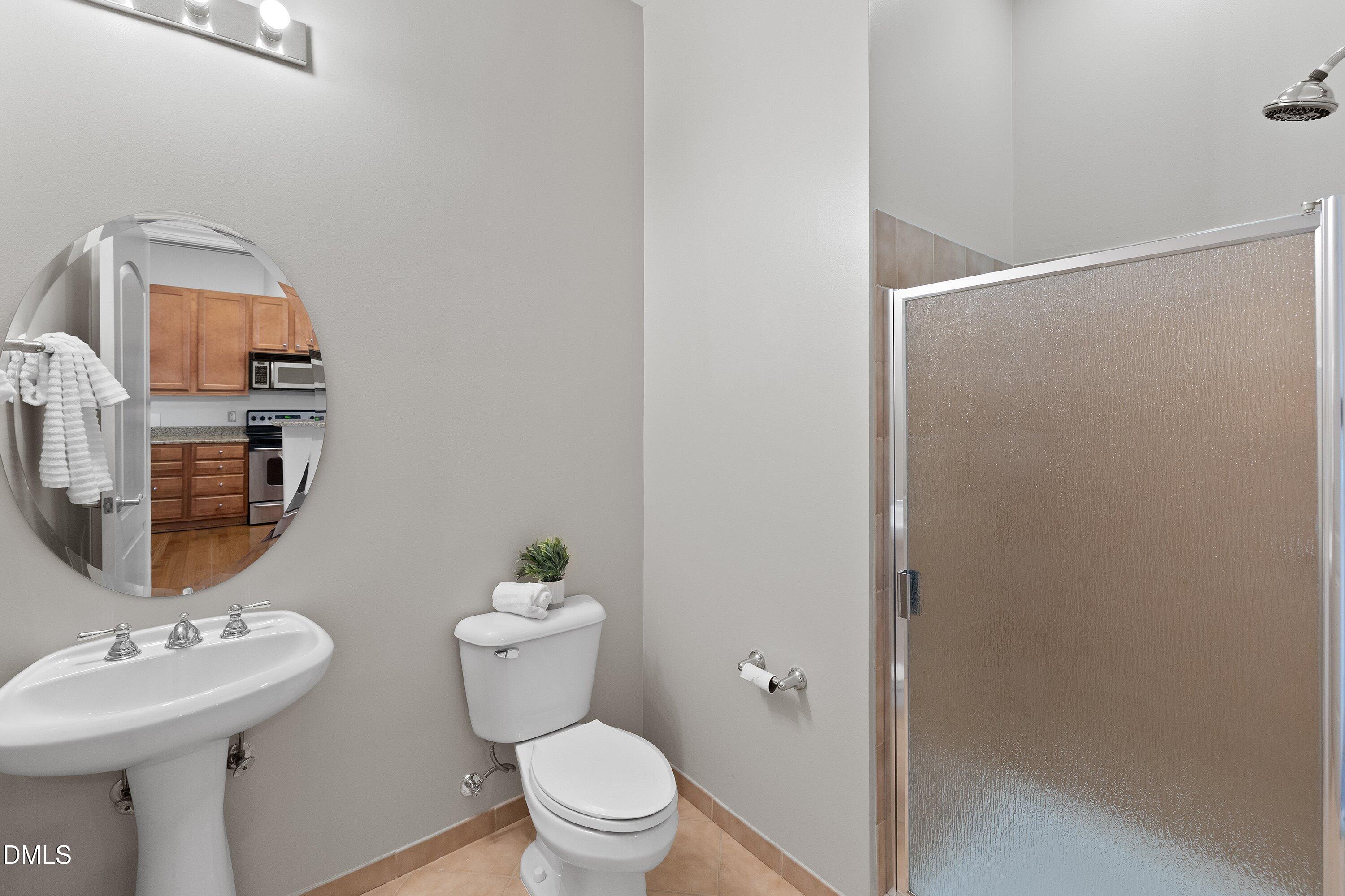 317 West Morgan Street, Unit 215 Raleigh, NC 27601 - Photo 26 of 38 a bathroom with a sink mirror and toilet