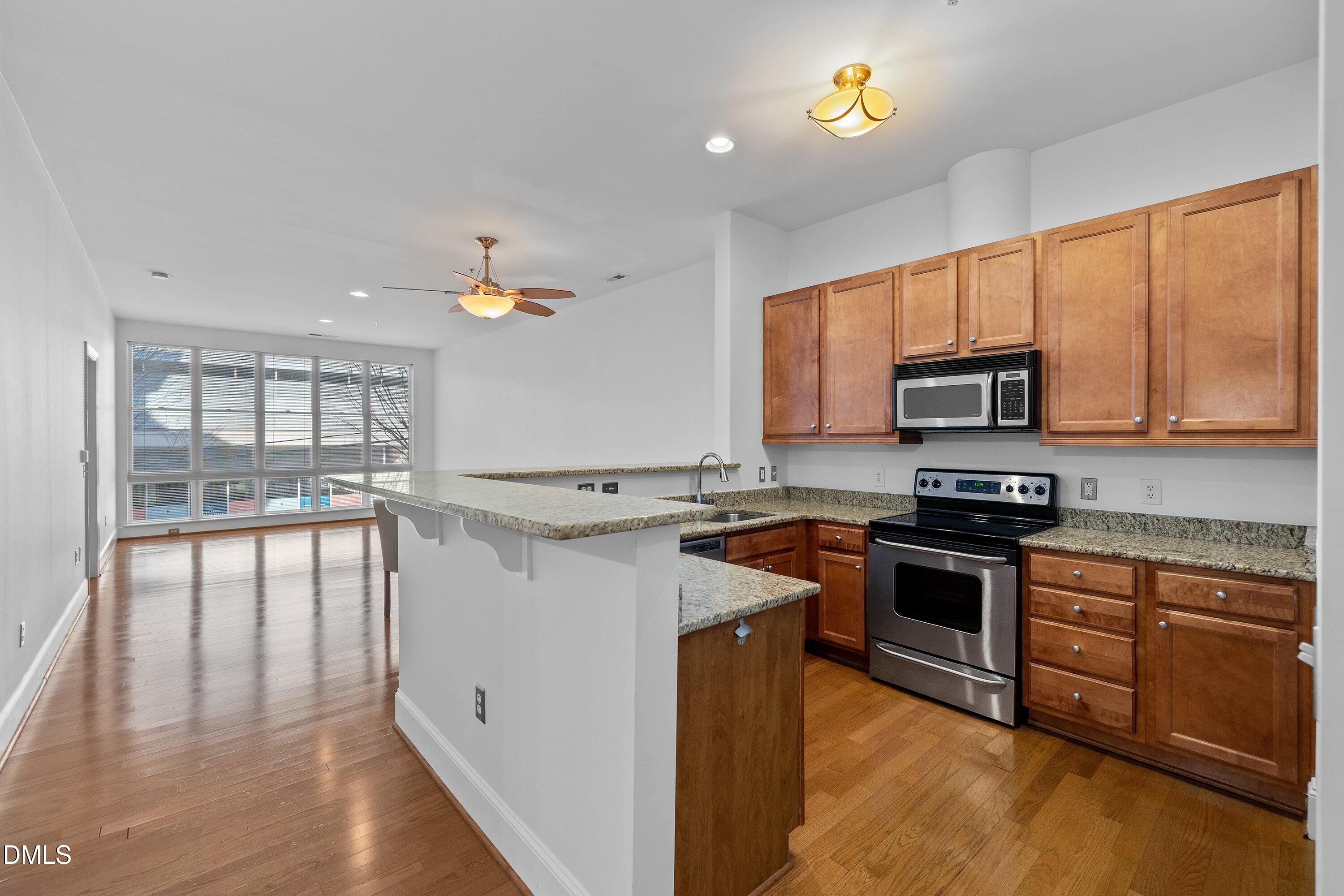 317 West Morgan Street, Unit 215 Raleigh, NC 27601 - Photo 4 of 38 a kitchen with a stove a sink and a microwave