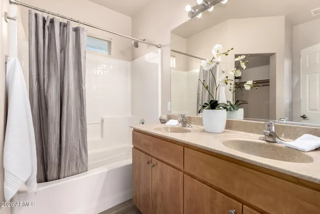 a bathroom with a granite countertop sink a mirror and a shower