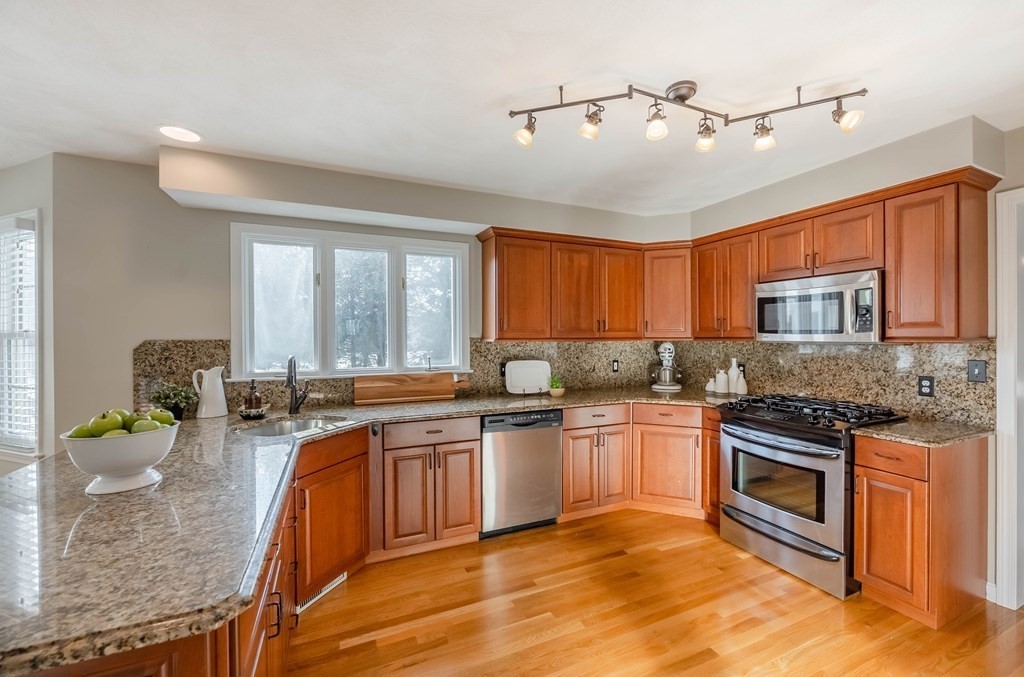 5 Devonshire Place Andover, MA 01810 - Photo 8 of 42 a kitchen with stainless steel appliances granite countertop a stove top oven a sink dishwasher and cabinets with wooden floor
