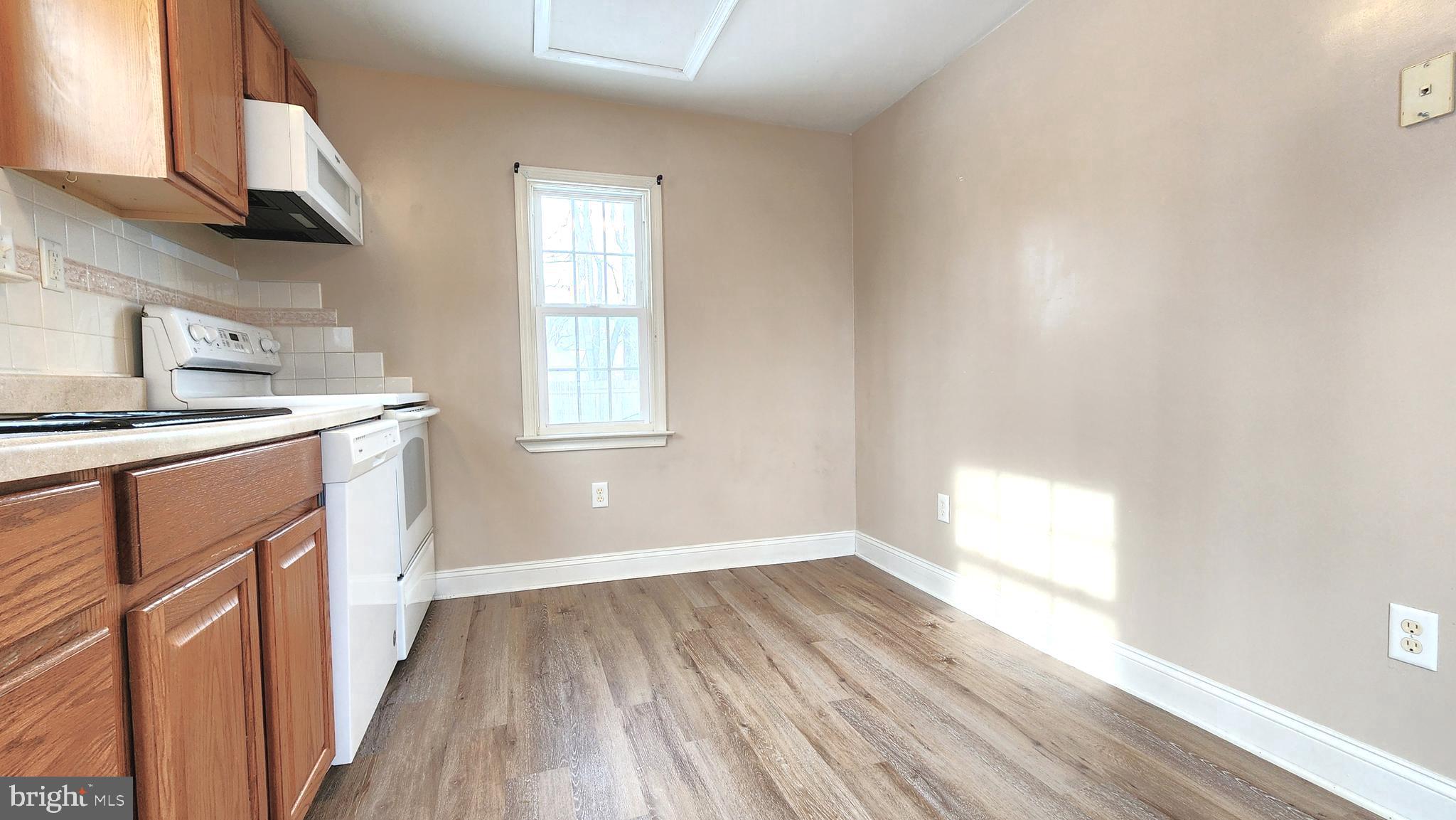 1122 Horsepond Road Dover, DE 19901 - Photo 13 of 26 a kitchen with a wooden floor stove top oven and sink