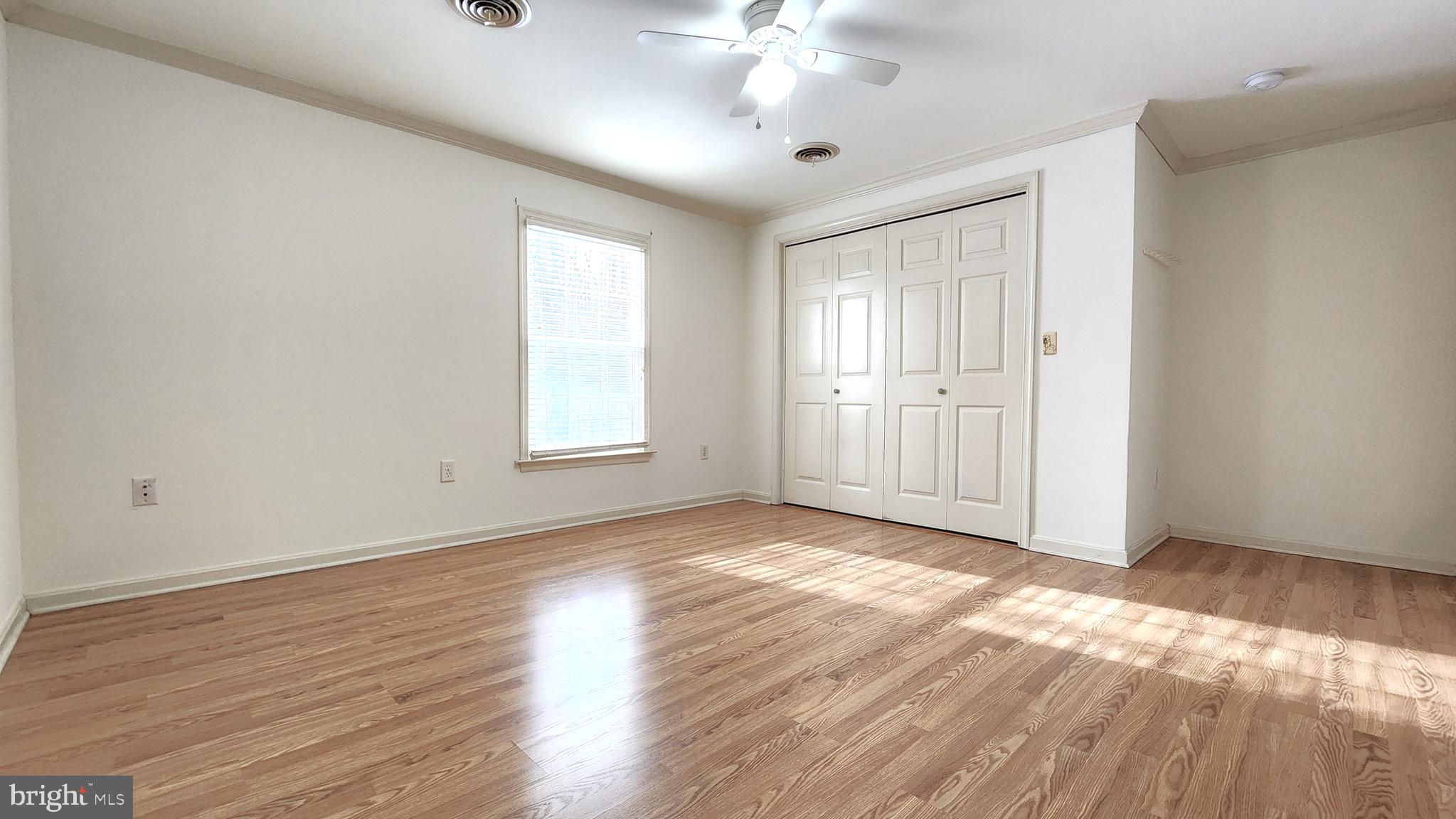 1122 Horsepond Road Dover, DE 19901 - Photo 15 of 26 an empty room with wooden floor chandelier fan and windows