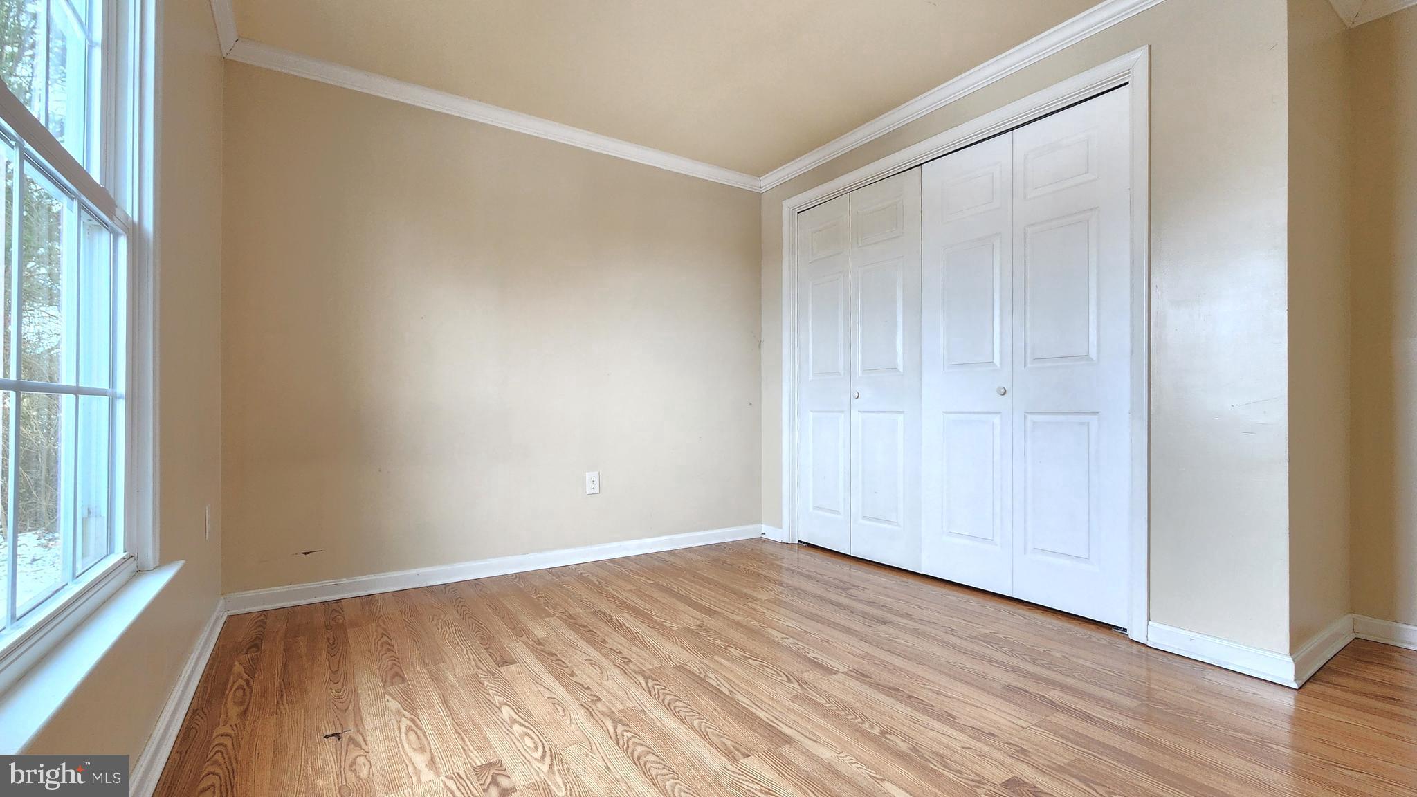 1122 Horsepond Road Dover, DE 19901 - Photo 18 of 26 a view of an empty room with wooden floor and a window