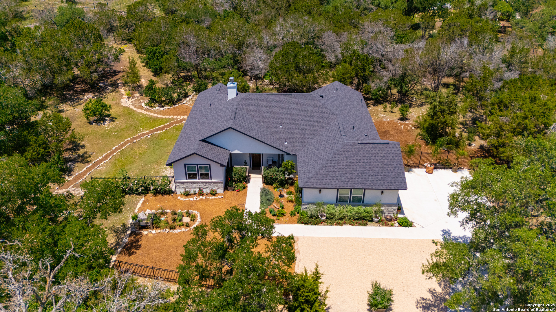 an aerial view of a house with yard and green space