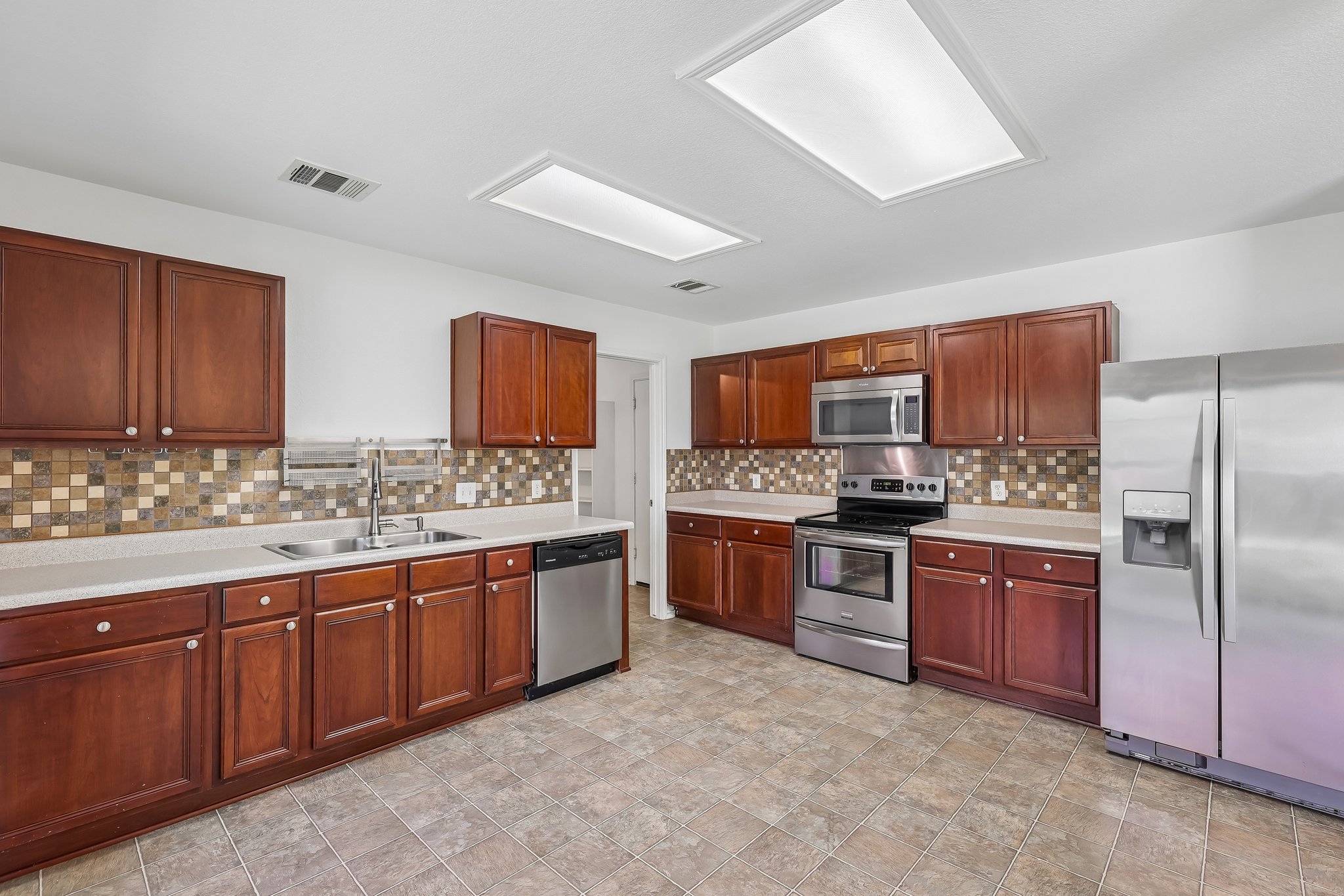 7658 Marble Ridge Drive Austin, TX 78747 - Photo 11 of 34 a kitchen with stainless steel appliances granite countertop a stove refrigerator sink and cabinets