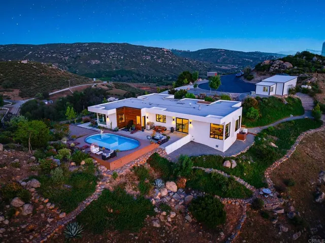 an aerial view of residential houses with outdoor space and mountain view