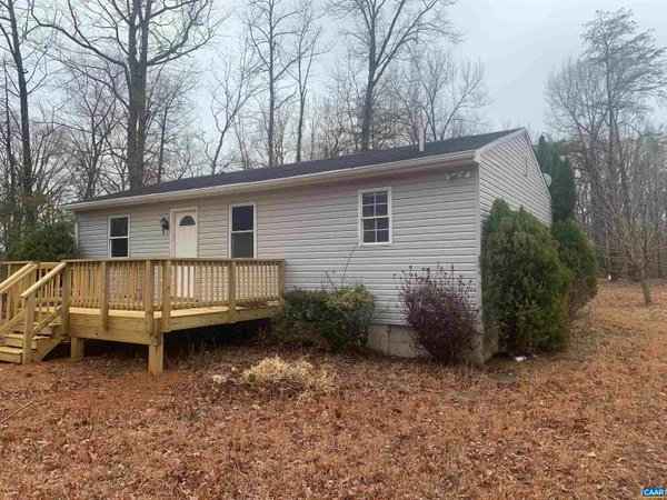 a view of a house with a backyard and wooden deck