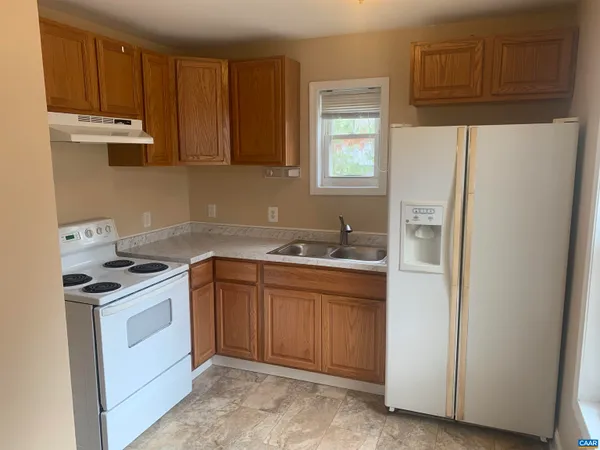 a kitchen with stainless steel appliances granite countertop a stove a refrigerator and a sink