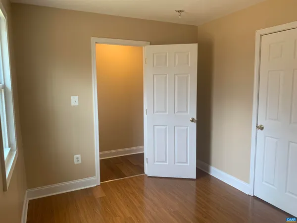 an empty room with wooden floor and closet