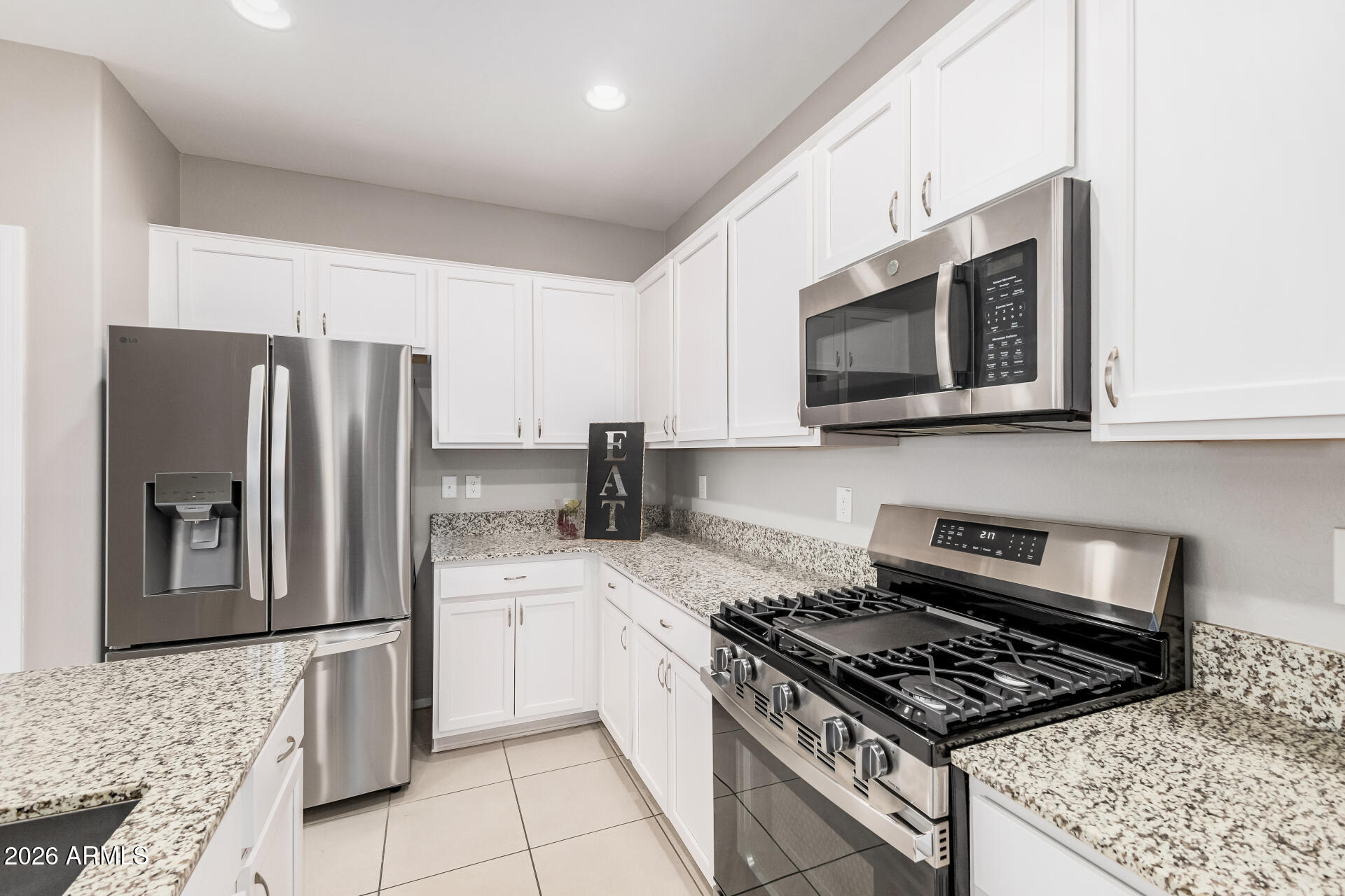 4228 West Coles Road Laveen, AZ 85339 - Photo 4 of 36 a kitchen with stainless steel appliances granite countertop a stove a refrigerator and a microwave