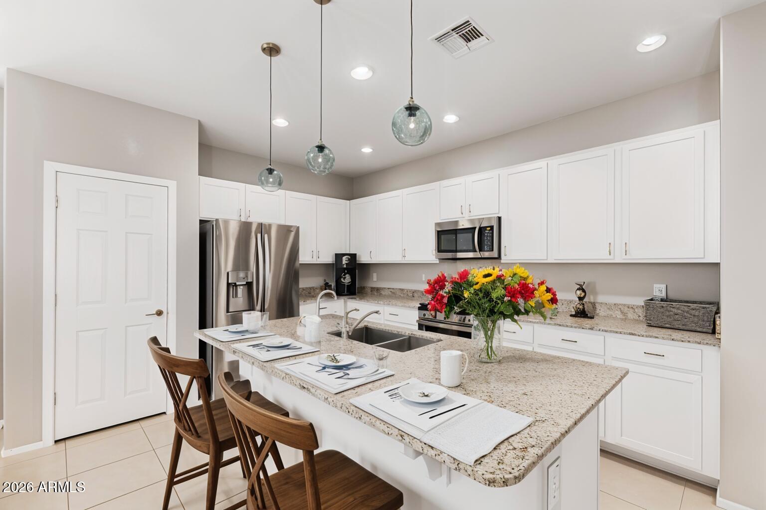 4228 West Coles Road Laveen, AZ 85339 - Photo 8 of 36 a kitchen with stainless steel appliances kitchen island granite countertop a dining table and chairs