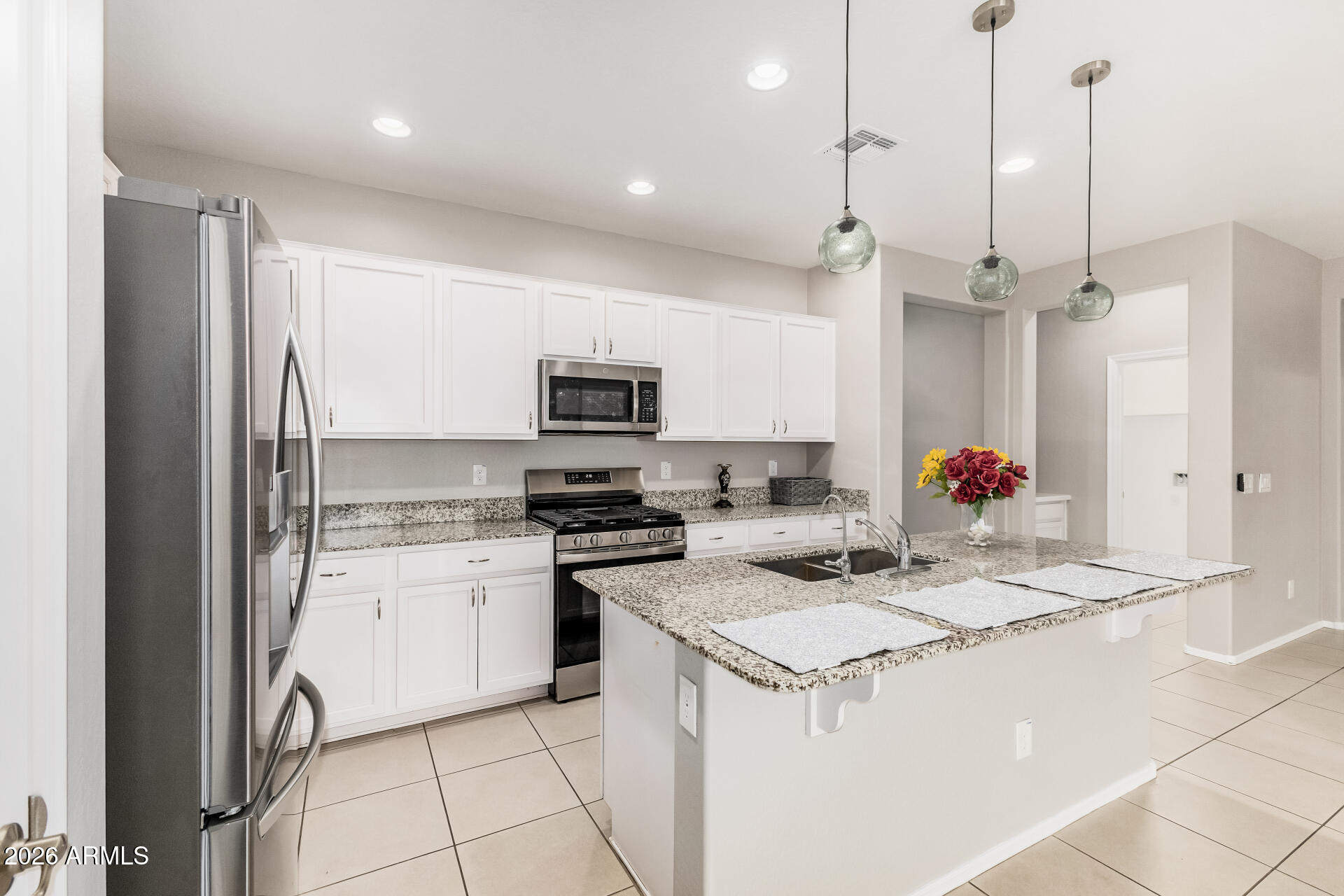 4228 West Coles Road Laveen, AZ 85339 - Photo 10 of 36 a kitchen with stainless steel appliances kitchen island granite countertop a stove a sink and a refrigerator