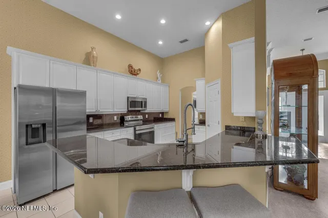 a kitchen with stainless steel appliances granite countertop a sink and a refrigerator