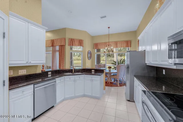 a kitchen with a sink a counter top space cabinets and appliances