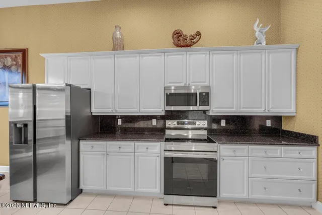 a kitchen with granite countertop white cabinets stainless steel appliances and sink
