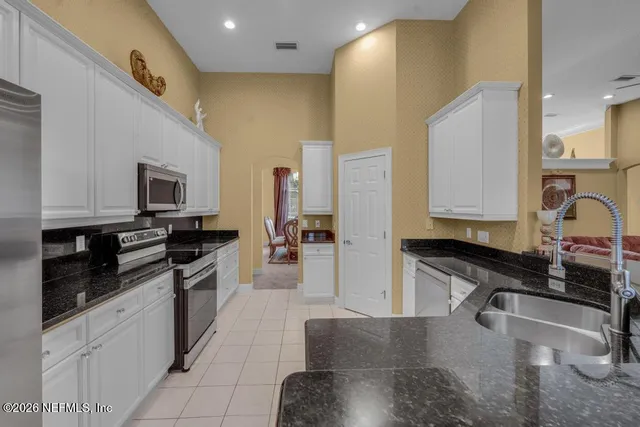 a kitchen with stainless steel appliances granite countertop a sink and a stove