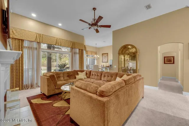 a living room with fireplace furniture and a large window