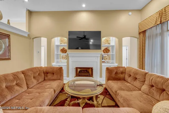 a living room with furniture a flat screen tv and a fireplace