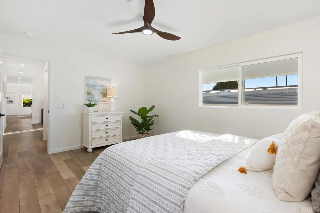 7144 Santa Rosa, Unit 86 Carlsbad, CA 92011 - Photo 21 of 41 a bedroom with a bed and a chandelier