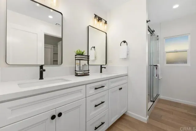 a bathroom with a double vanity sink mirror and shower