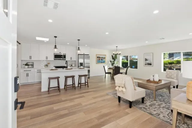 a living room with lots of furniture and kitchen view