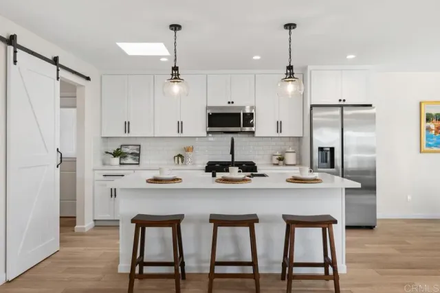 a kitchen with white cabinets and stainless steel appliances