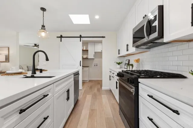 a kitchen with stainless steel appliances a stove sink and cabinets