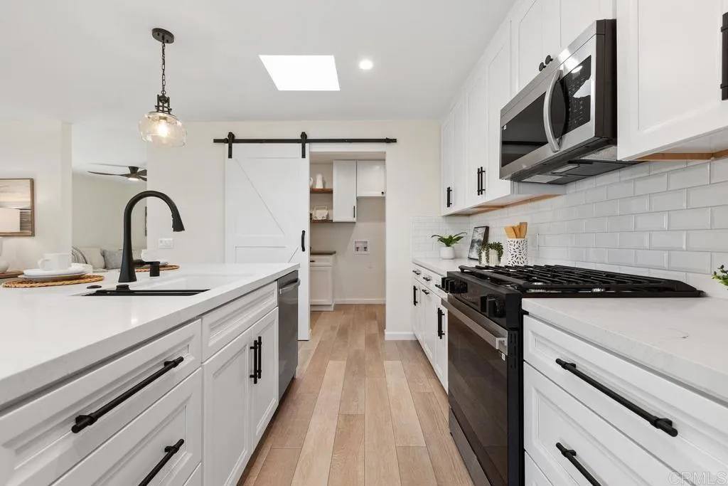 7144 Santa Rosa, Unit 86 Carlsbad, CA 92011 - Photo 10 of 41 a kitchen with stainless steel appliances a stove sink and cabinets