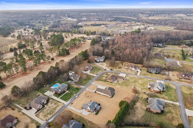 a view of a room with wooden floor fan and windows