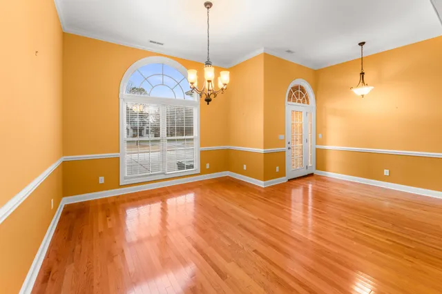 a kitchen with stainless steel appliances granite countertop a stove top oven a sink dishwasher and a refrigerator with wooden floor