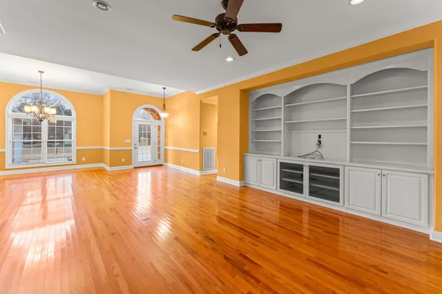 a kitchen with granite countertop a sink stainless steel appliances white cabinets and a window