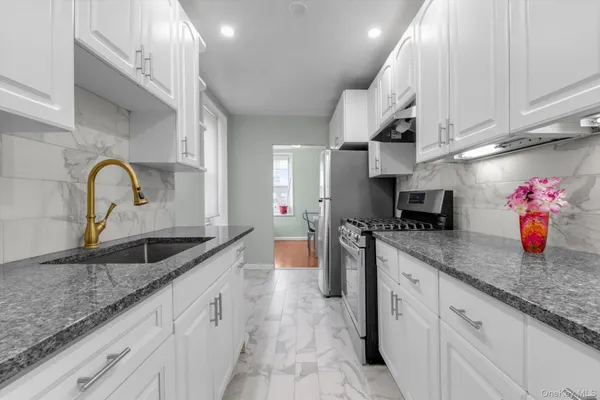 a kitchen with granite countertop a sink stainless steel appliances and cabinets