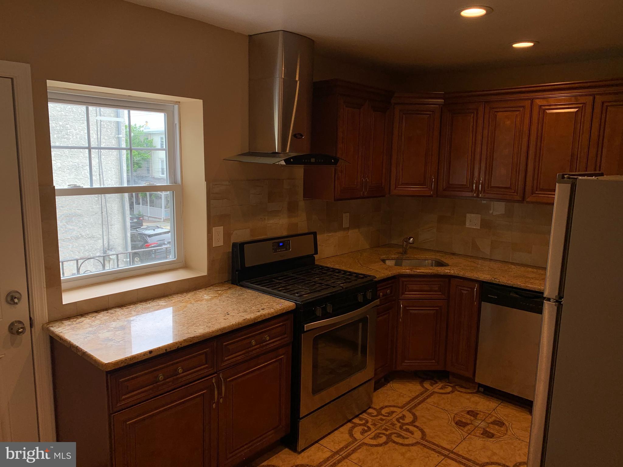 3350 Conrad Street, Unit B Philadelphia, PA 19129 - Photo 4 of 16 a kitchen with stainless steel appliances granite countertop a stove a sink and a refrigerator