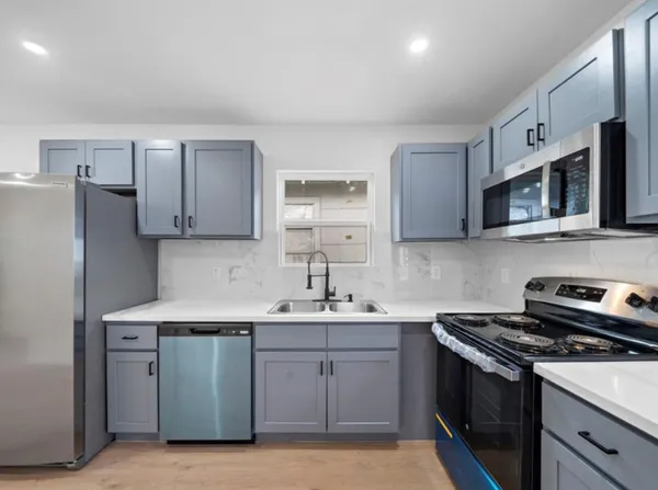 a kitchen with stainless steel appliances a sink stove and refrigerator