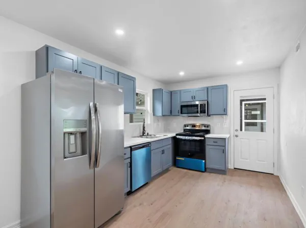 a kitchen with stainless steel appliances granite countertop a refrigerator stove and sink