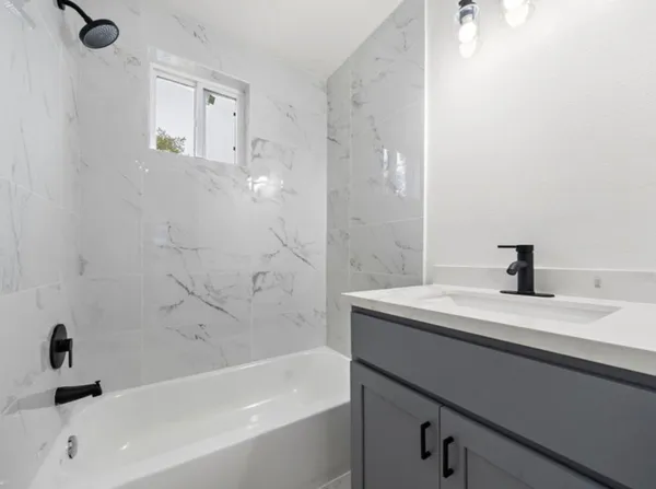 a bathroom with a sink a mirror and a bathtub