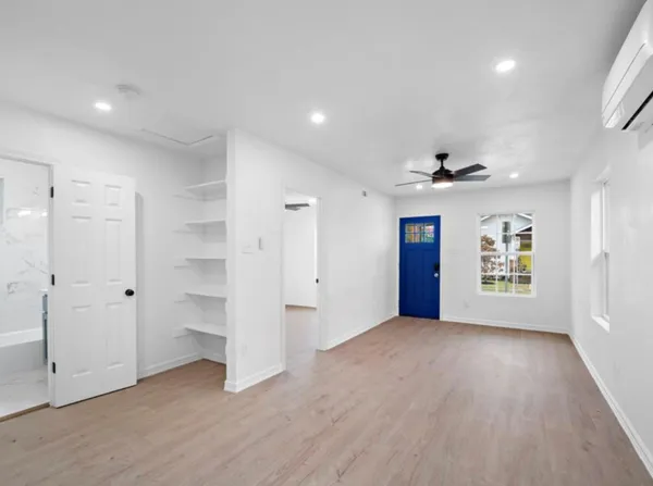 an empty room with closet and windows