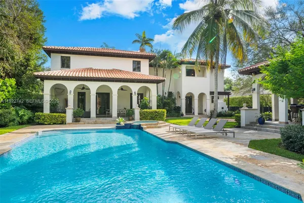 a view of house with swimming pool and sitting area