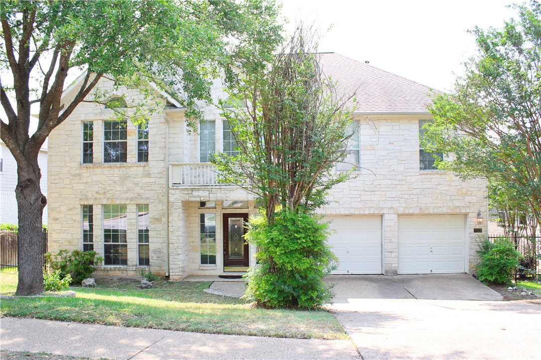 a front view of a house with a yard and trees