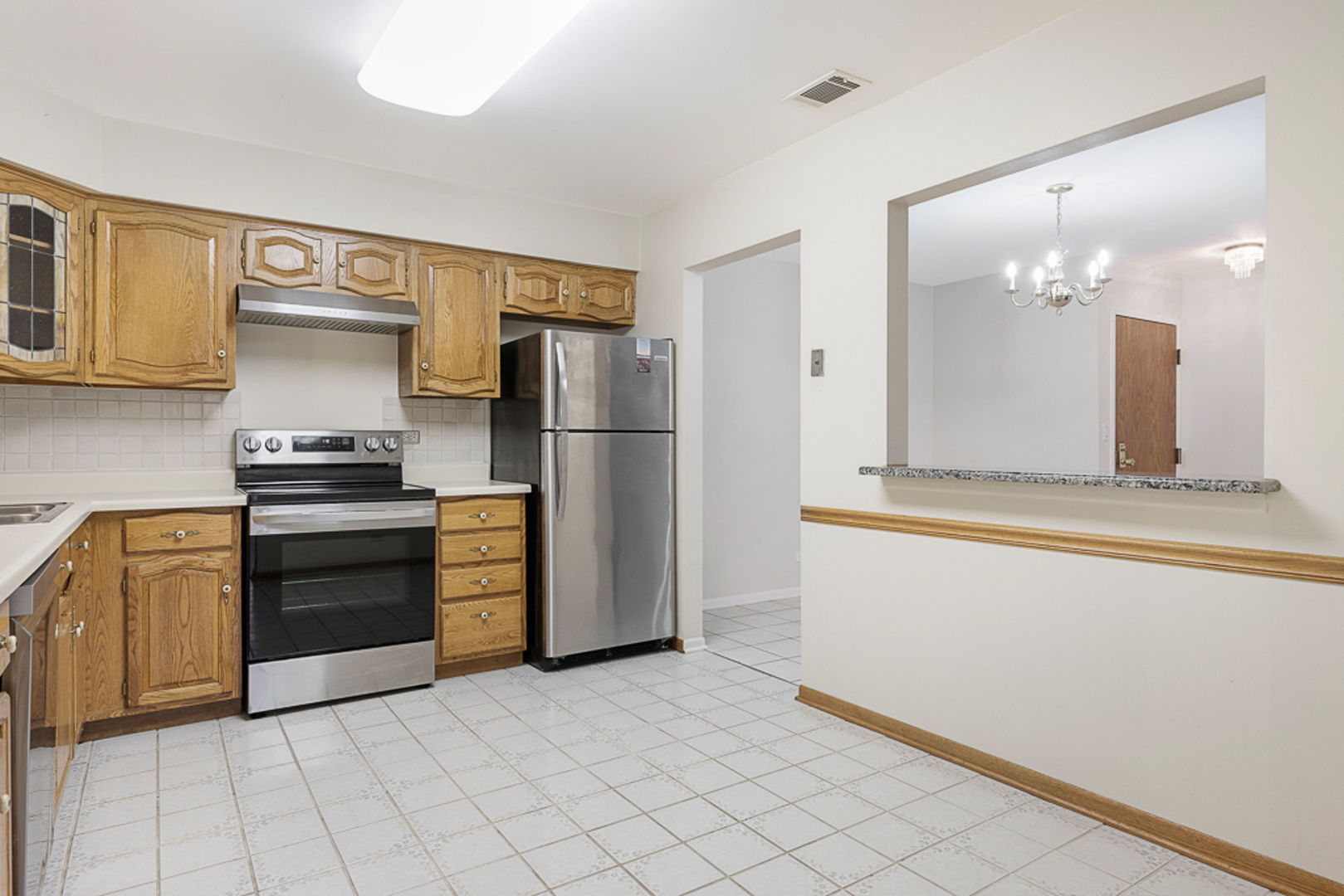 801 79th Street, Unit 103 Darien, IL 60561 - Photo 6 of 19 a kitchen with a refrigerator and a stove