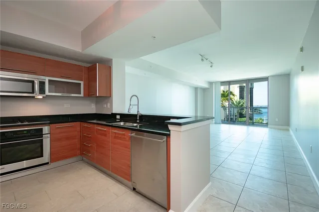 a kitchen with stainless steel appliances granite countertop a stove a sink and a refrigerator